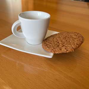 Sehr dünner Kaffeekeks am Rand einer weißen Espressotasse