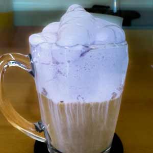 Ube Kaffee Latte im Glas - unten Kaffee, darüber die leicht Lila Haube