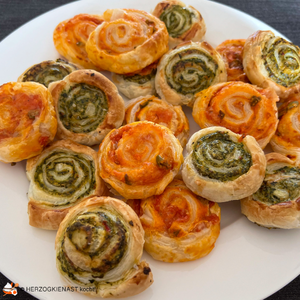 Ein Teller Blätterteigschnecken mit rotem und grünem Pesto