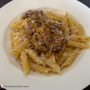 Ragout alla neapoletana auf einem Teller mit Parmesan getoppt