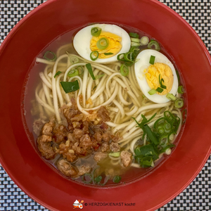 Ramen mit Hackfleisch und Ei im roten Bowl serviert