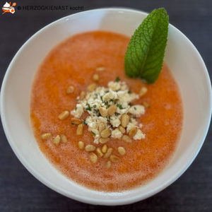 Melonensuppe mit Feta, angerichtet in weißer Schale