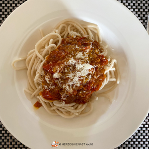 Hausgemachte Pasta mit deftiger Tomatensauce, getoppt mit frisch geriebenem Parmesan
