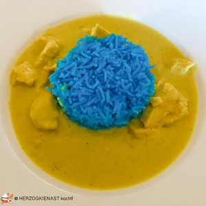 Blauer Reis umringt von gelbem Curry
