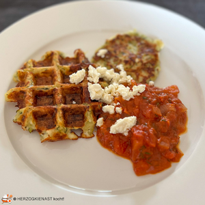 Zucchin waffles and patties served with sauce and topped with feta cheese