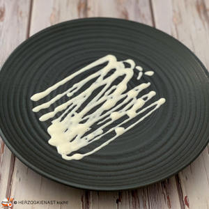 Japanische Mayo auf einem schwarzen Teller gespenkelt