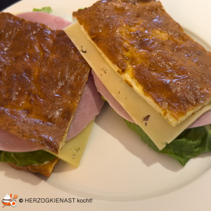 Keto Foccaccia, hier als Sandwich mit Schinken, Käse, Salat und Gurken belegt