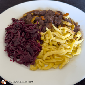 Hirsch-Stroganoff mit Spätzle und Aronia Rotkohl auf einem weißen Teller