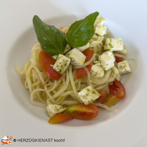 Zucchininudeln mit Tomaten und Mozzarella auf einem Teller