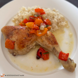 Hähnchenschenkel mit roter Paprika, serviert mit Reis
