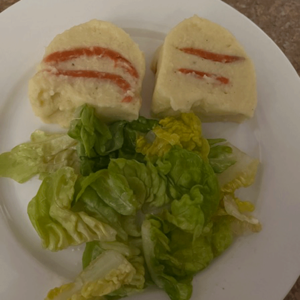 2 Scheiben Räucherlachsterrine mit Salat auf weißem Desserteller